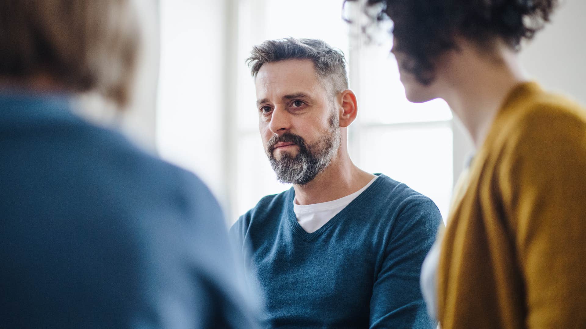 man sitting in meeting with ordinary people