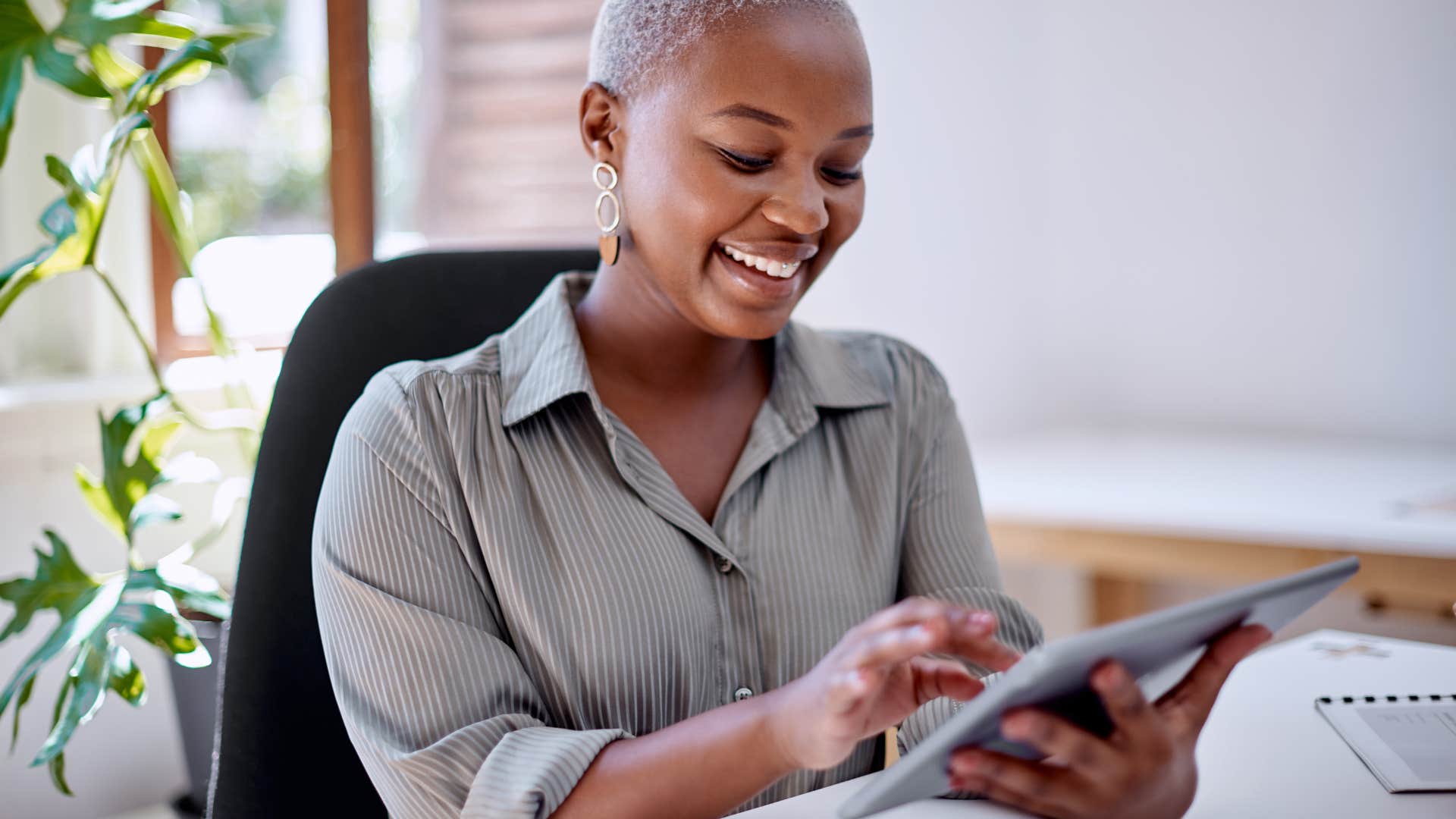 methodical woman working on tablet in office