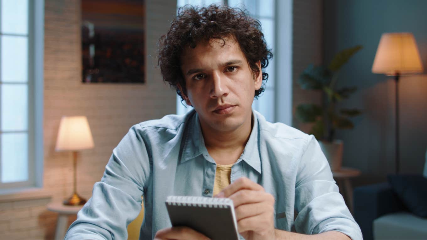 man with a notepad looking judgmental