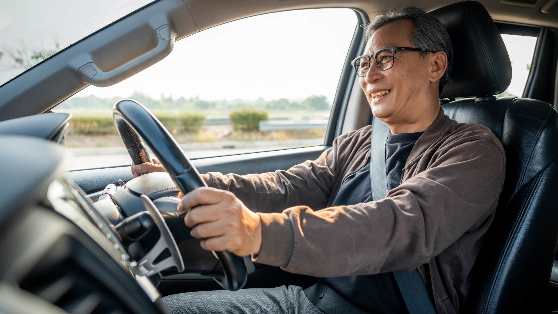 frugal man smiling and driving an old car