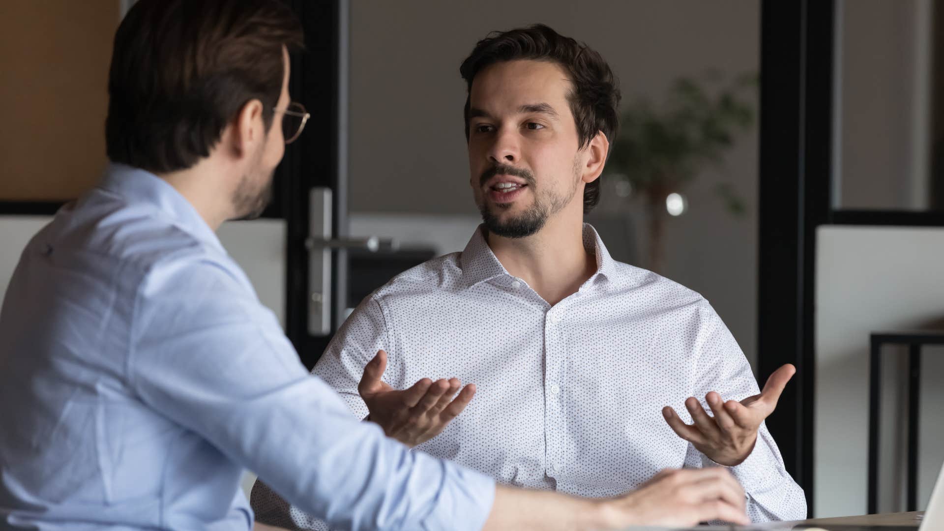 man talking to his co-worker who's an enabler