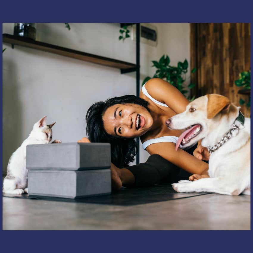 woman playing with cat and dog
