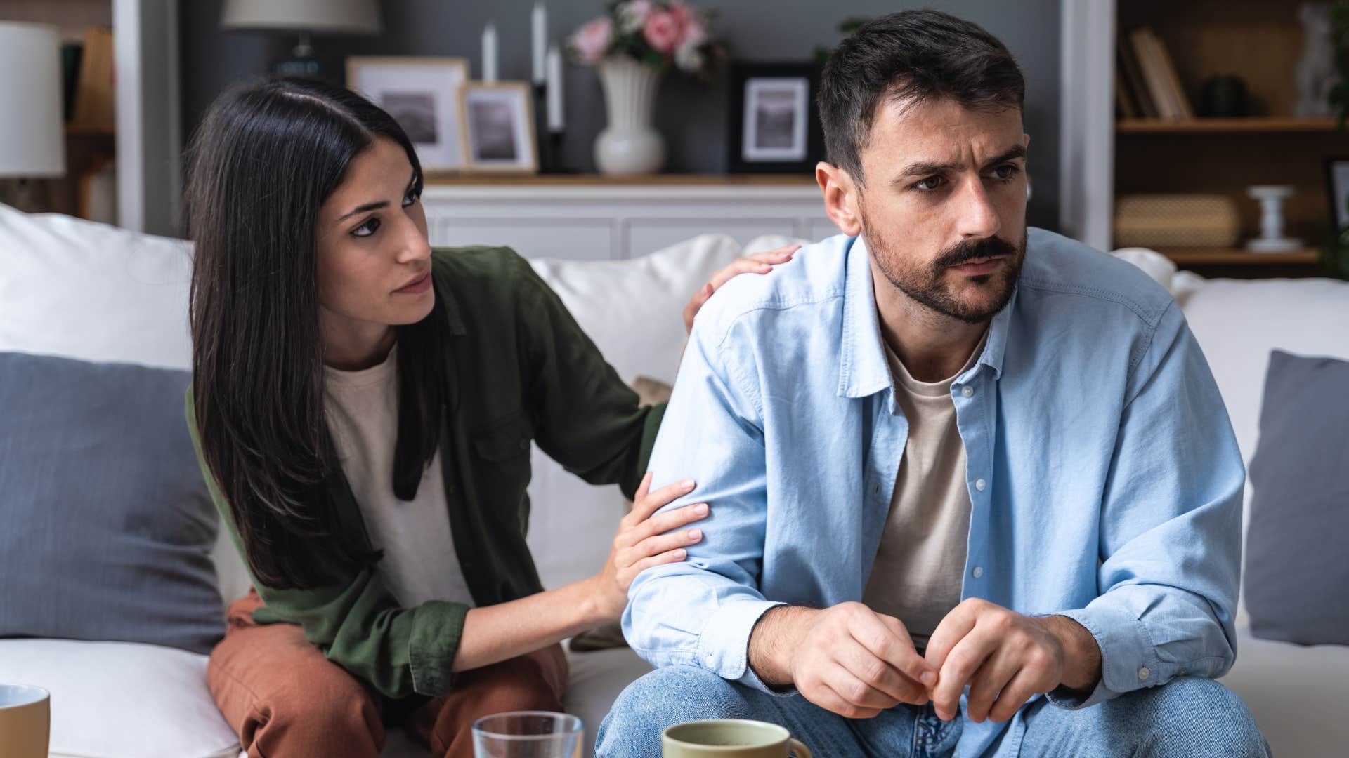 Woman turned away from her husband who reacts immediately.