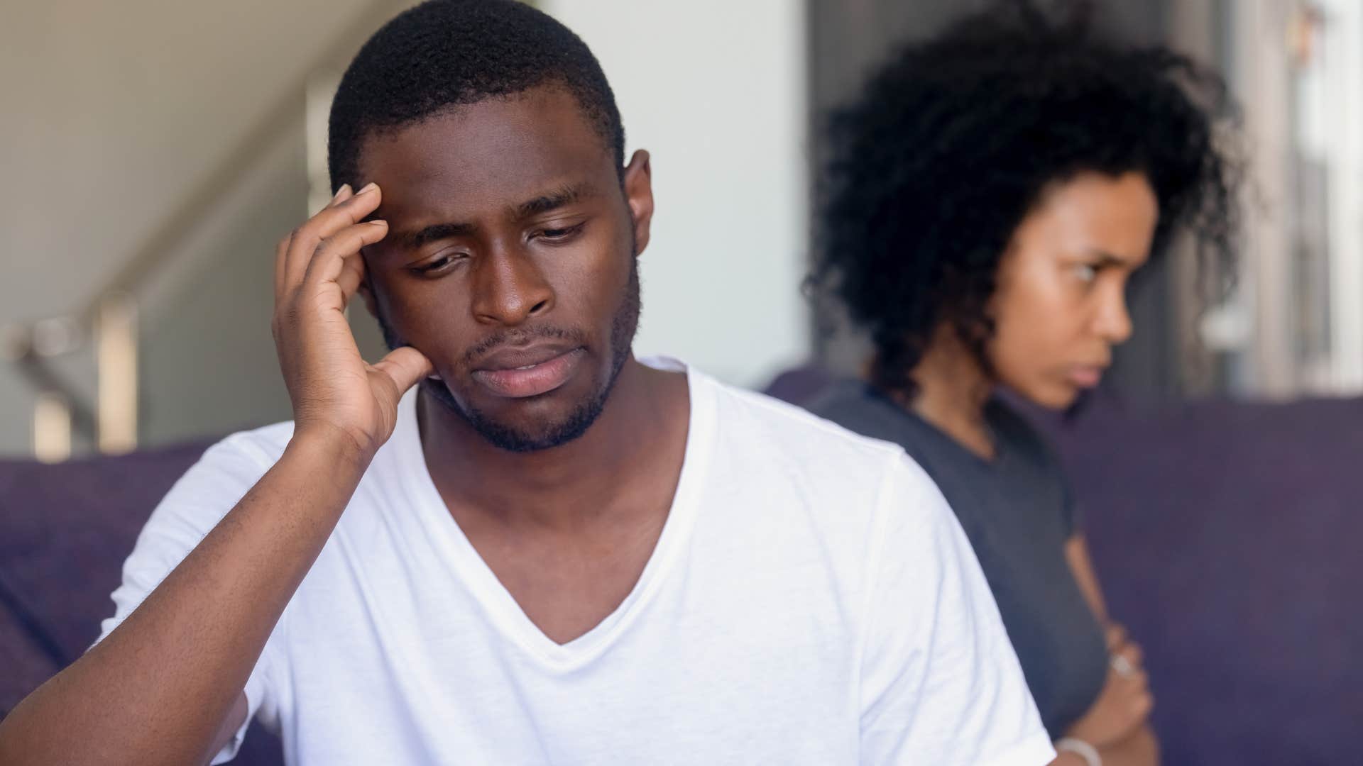 Man who will shut down emotionally turned away from his wife.