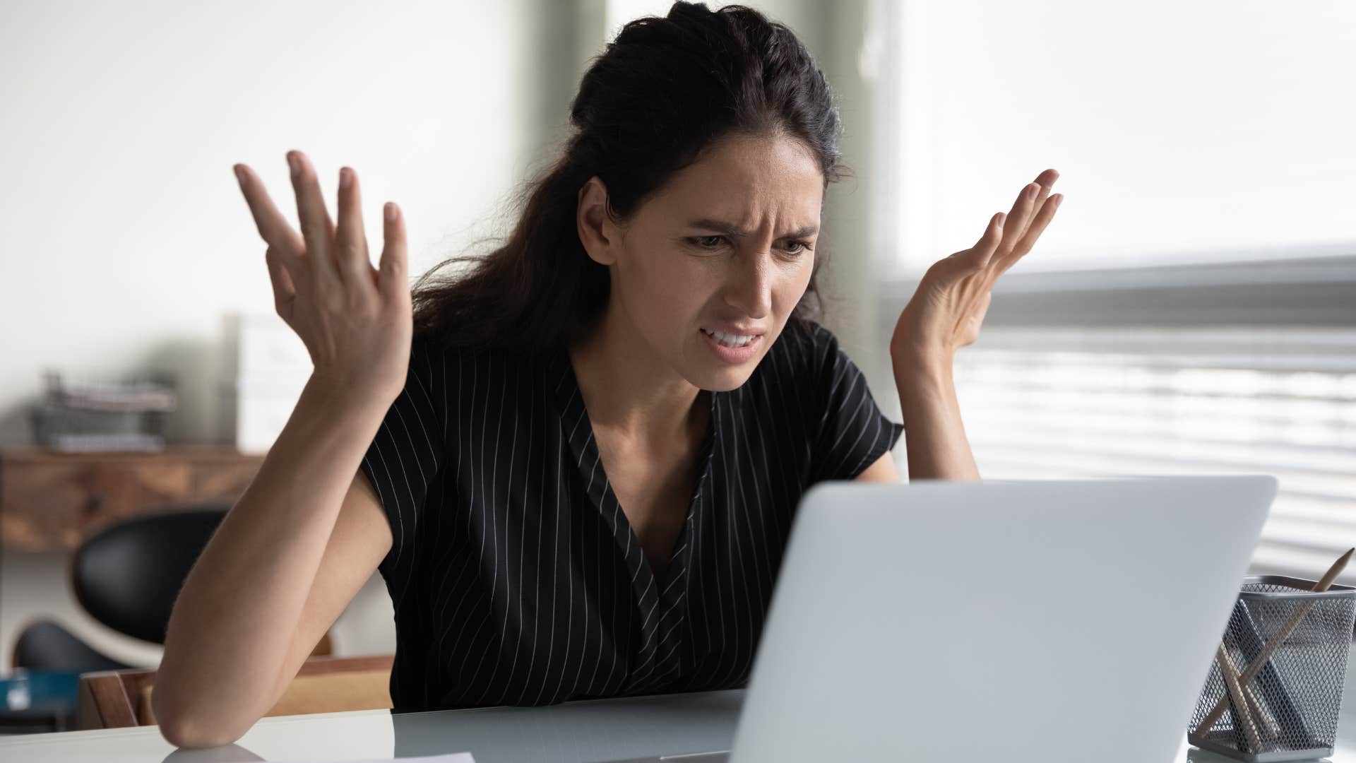 Woman saying "I did all my work, so I deserve a raise" at her laptop.