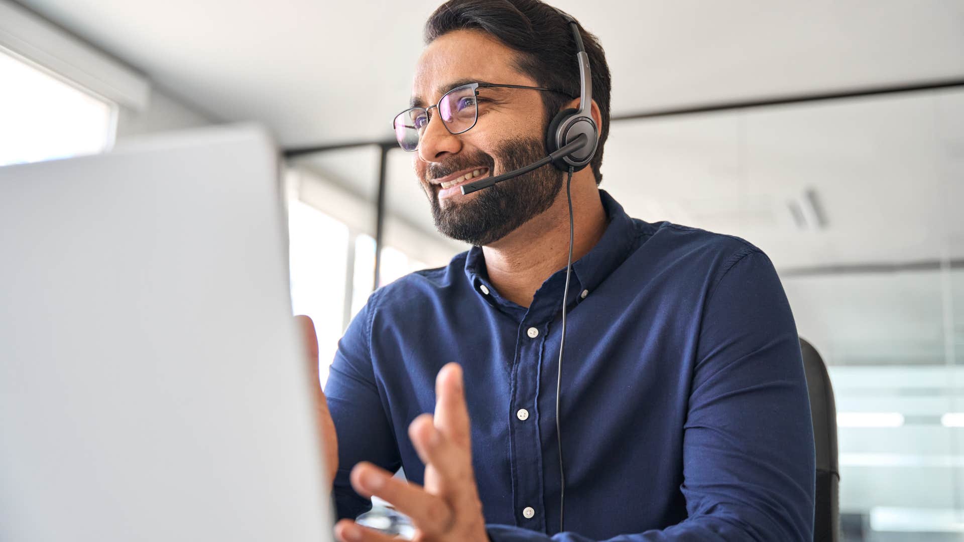 man saying tell me more into a headset at work