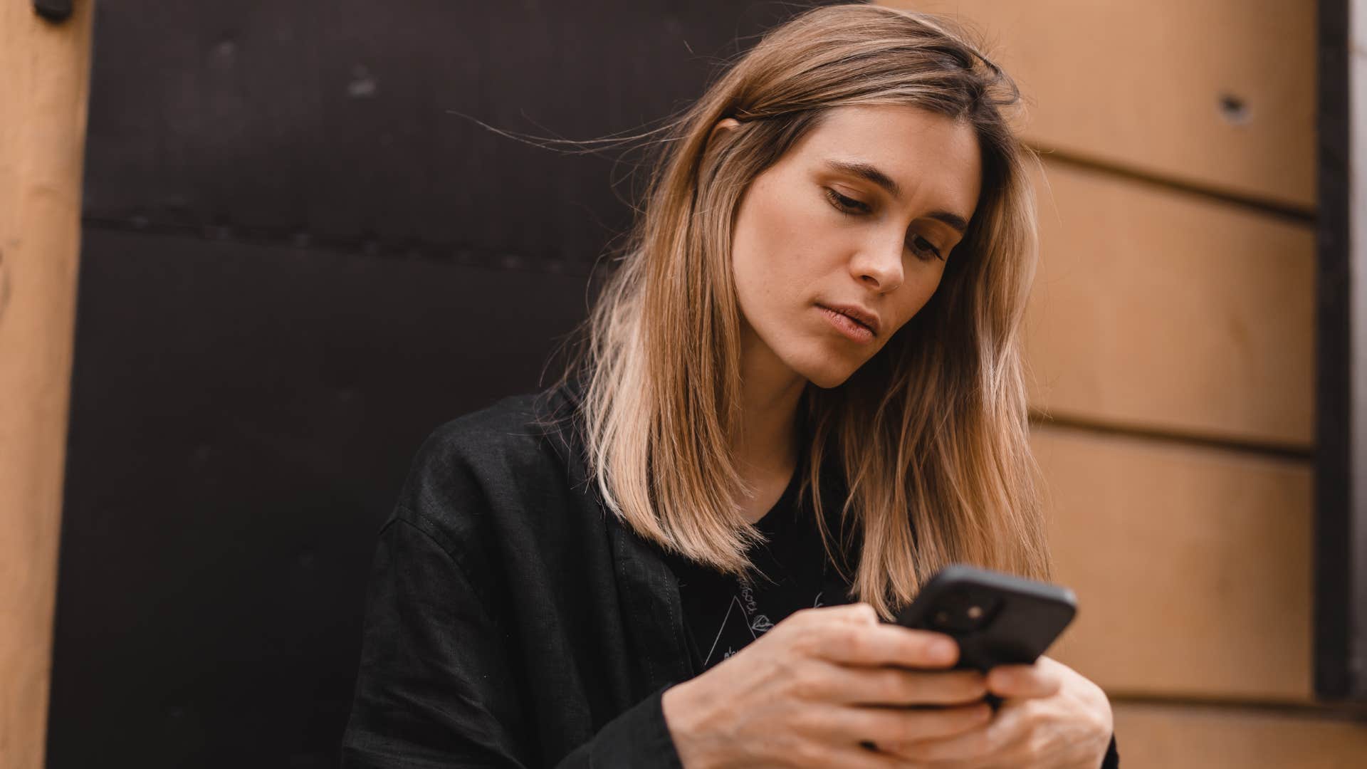 woman who's stopped calling husband for no reason looking at her phone