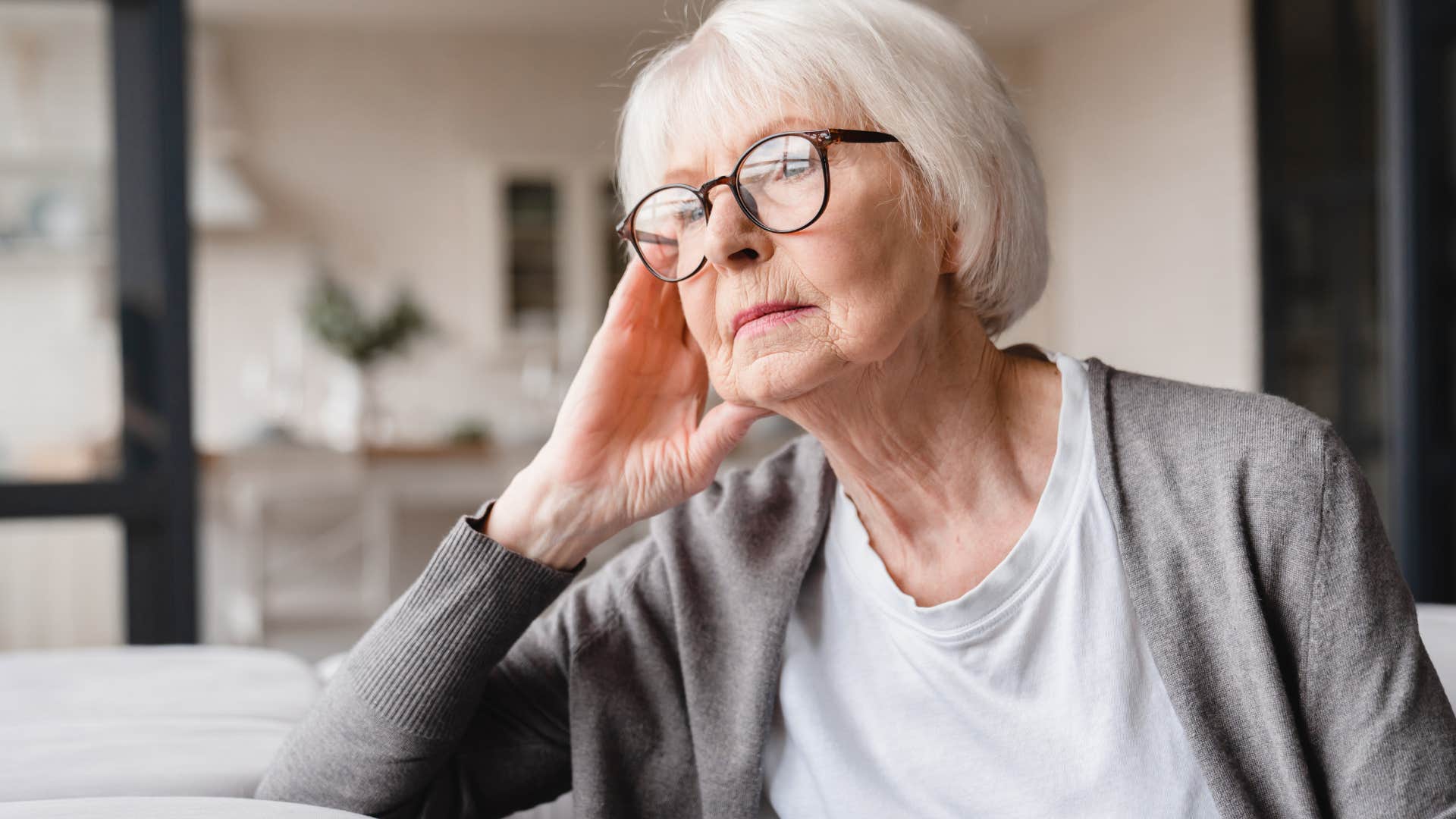 older woman not expressing vulnerability sitting at home