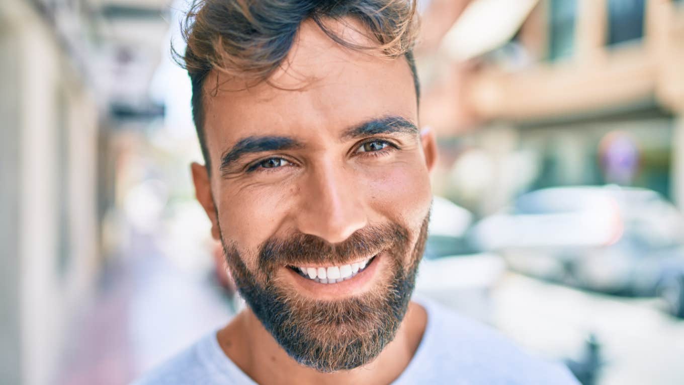 good man smiling standing outside