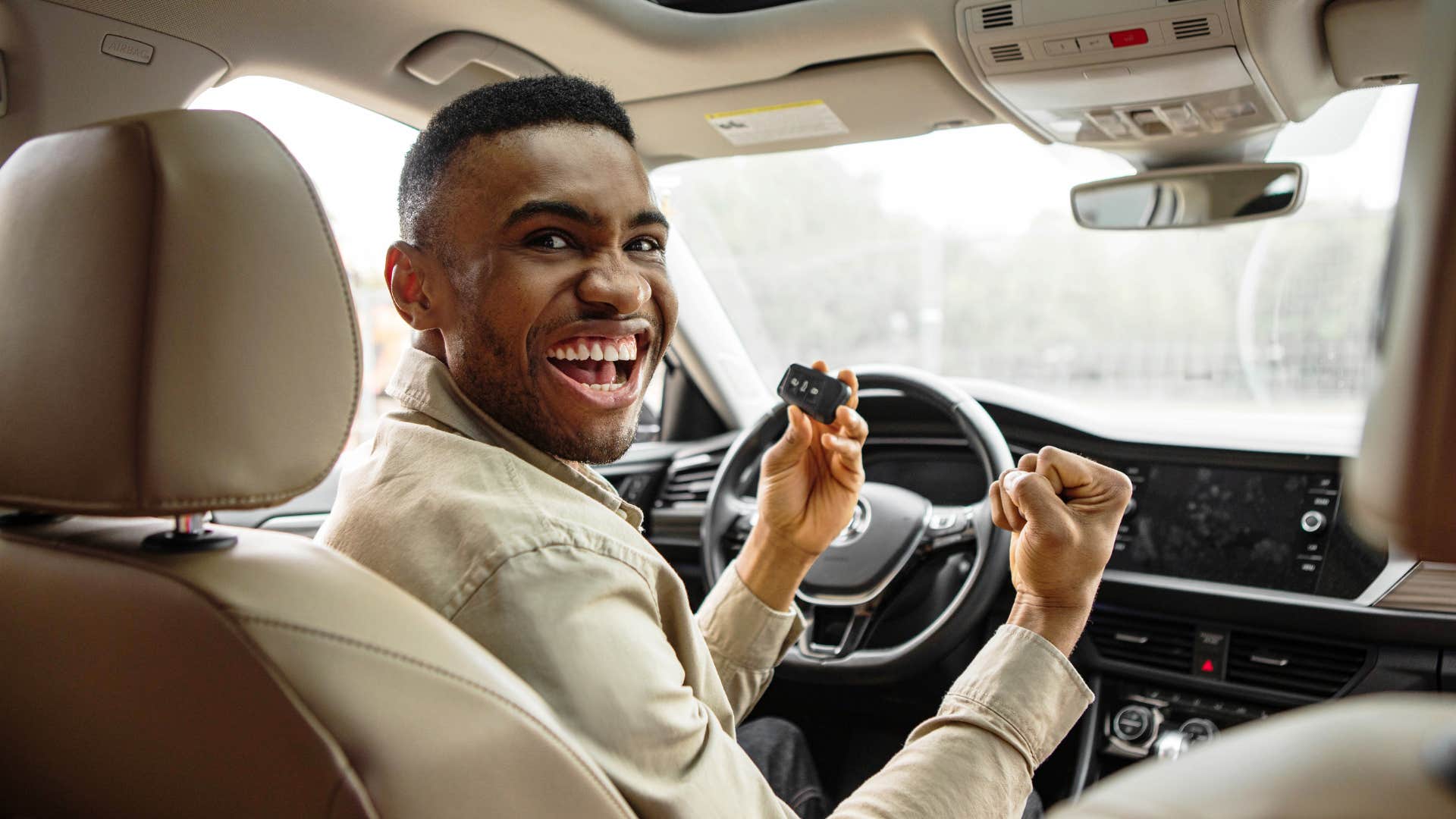 millennial man driving luxury car
