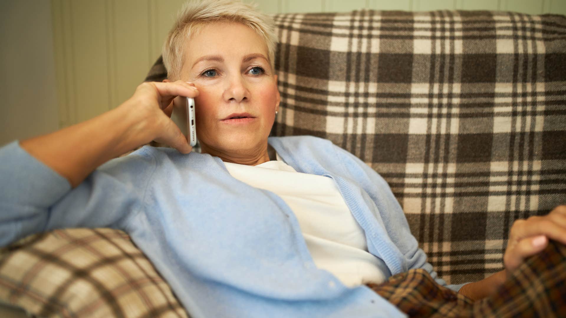 Woman saying "It's so noisy at my place, you won't be able to relax" on her phone.