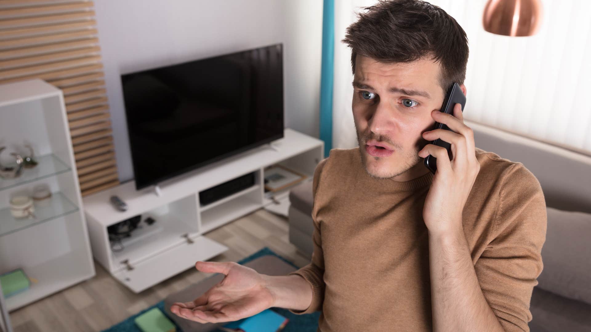 Man saying "it's a work in progress" on the phone at home.
