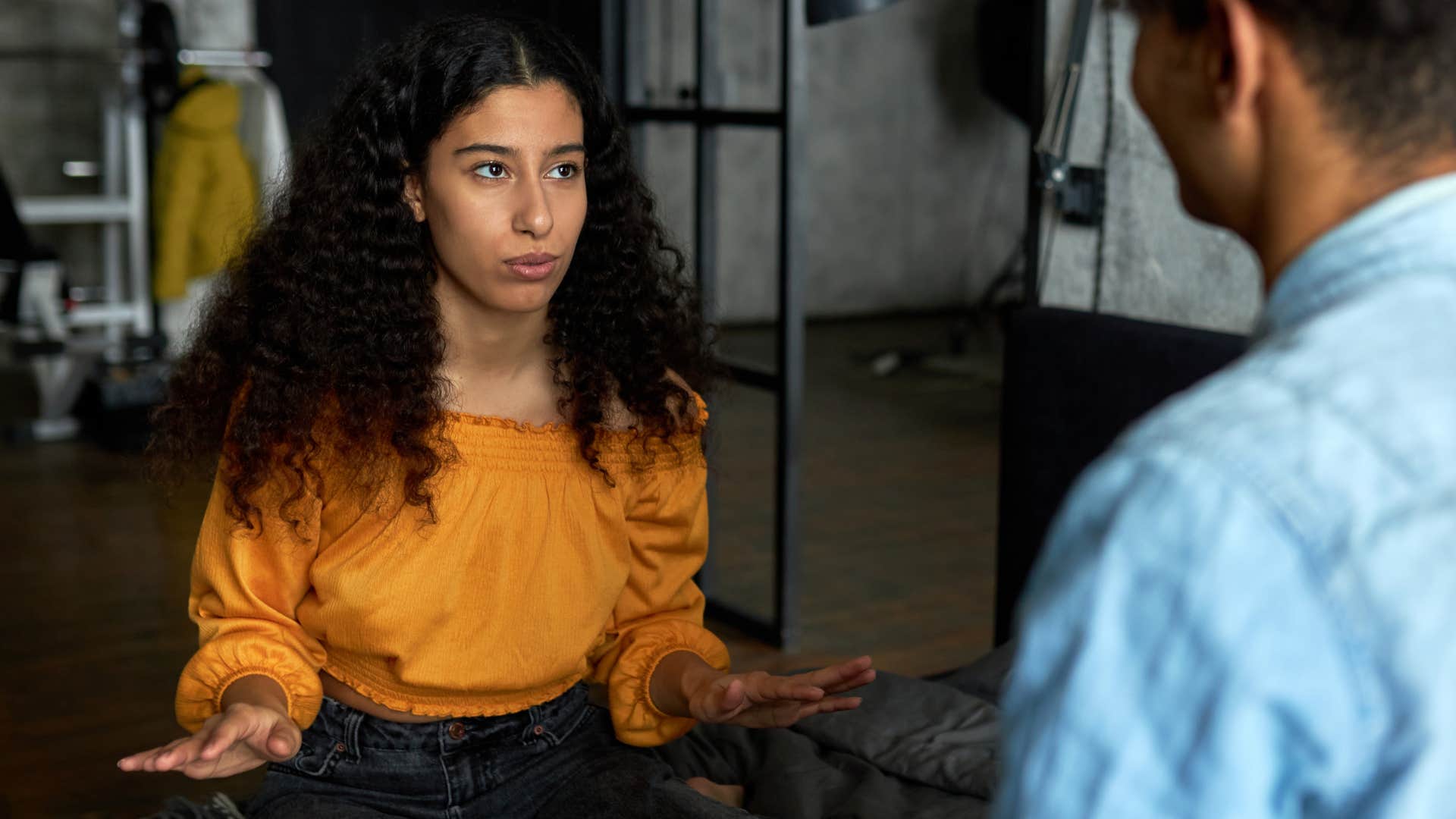Woman saying "I swear it doesn't normally look like this" to a man.
