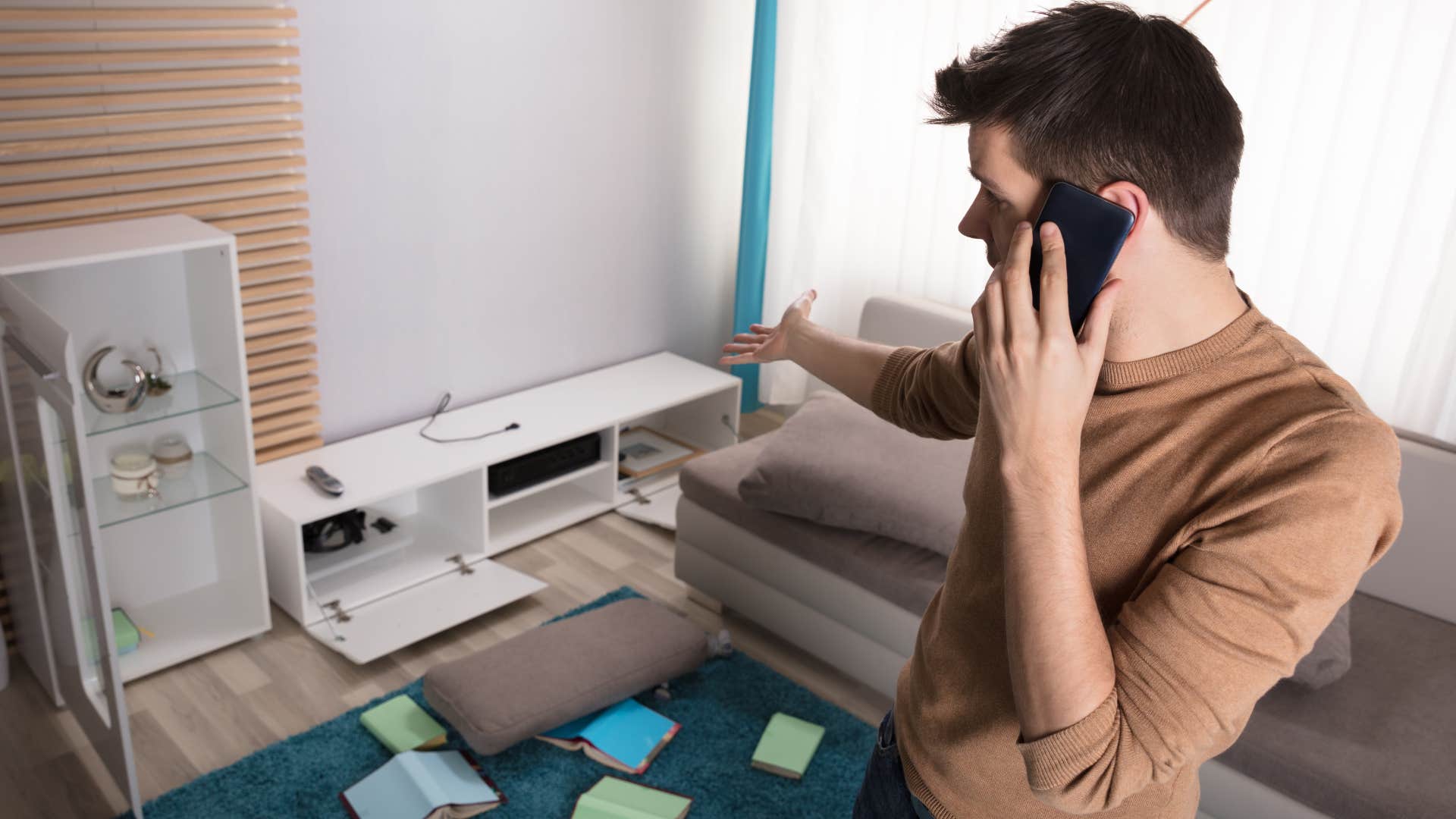 Man saying "it's a work in progress" on the phone at home.