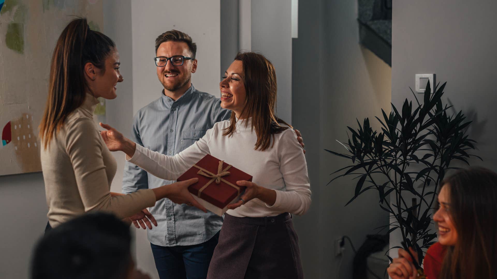 couple bringing a gift for host of party