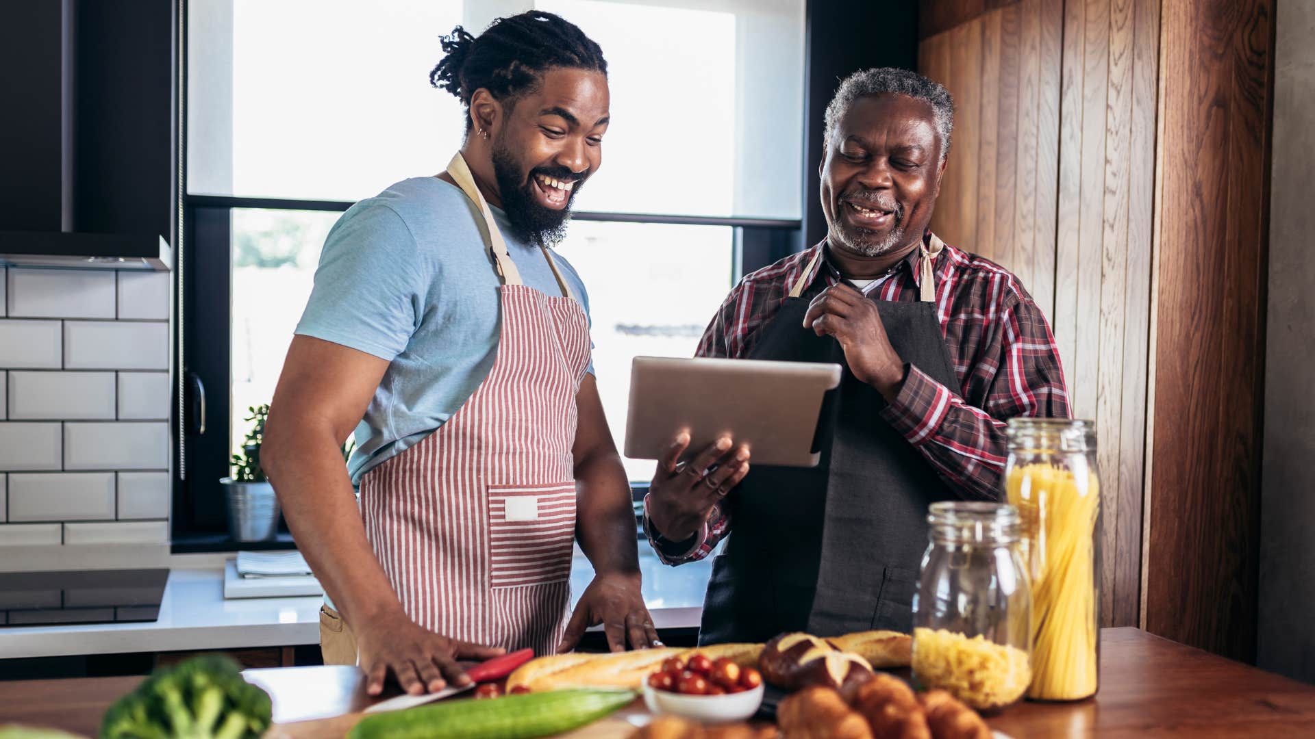 man standing with his dad in the kitchen learning recipes