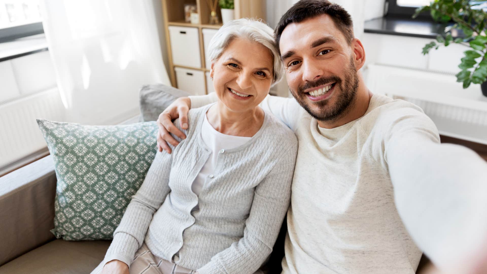 man smiling with his mother showing an interest in her hobbies