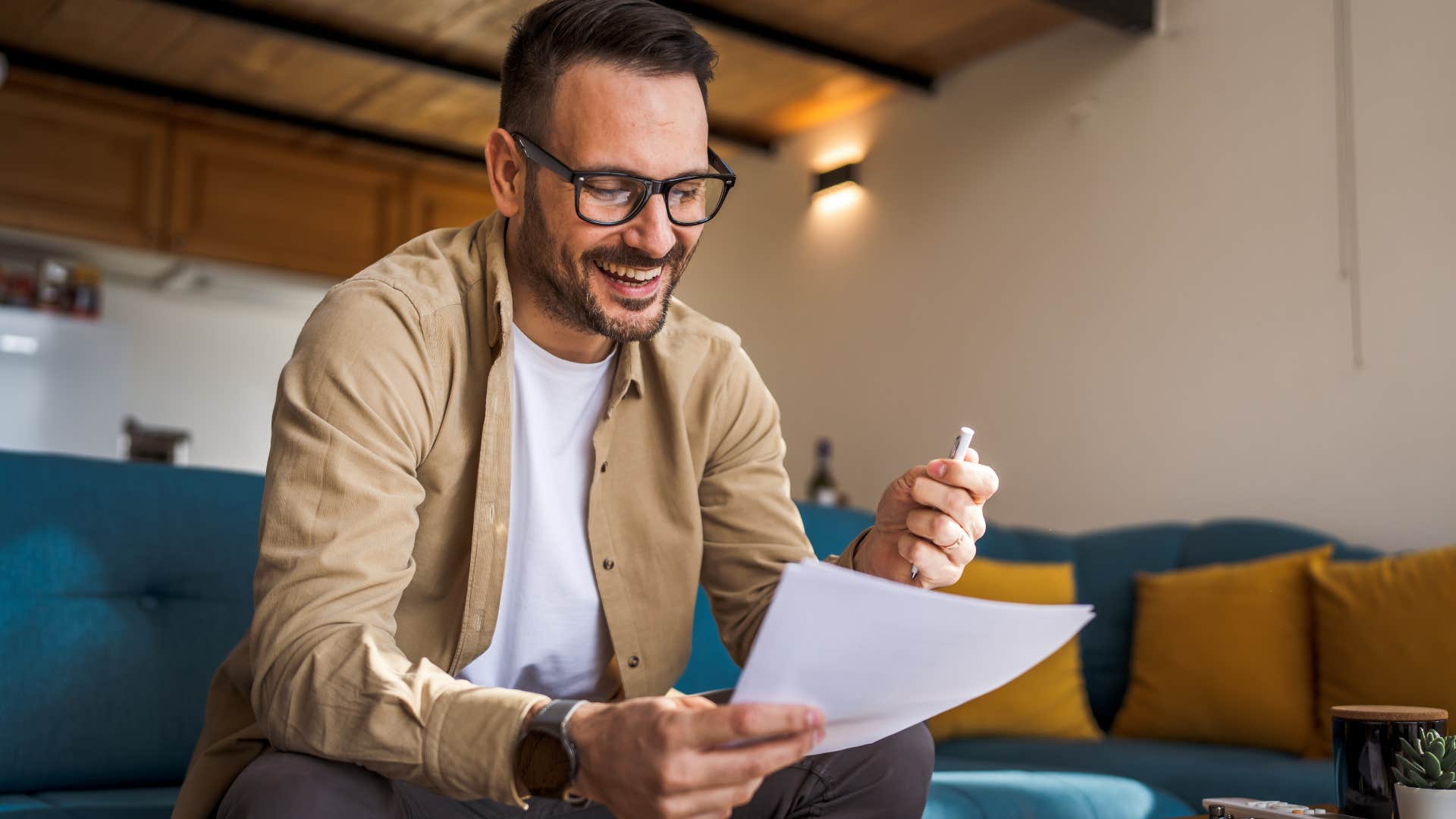 man writing a handwritten letter to his parents