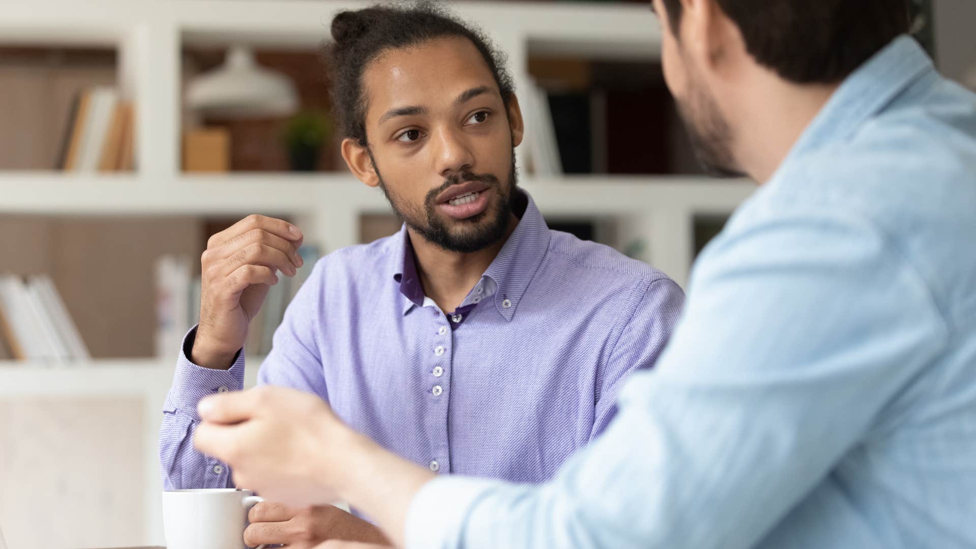 man hiding his true confidence while talking to a co-worker