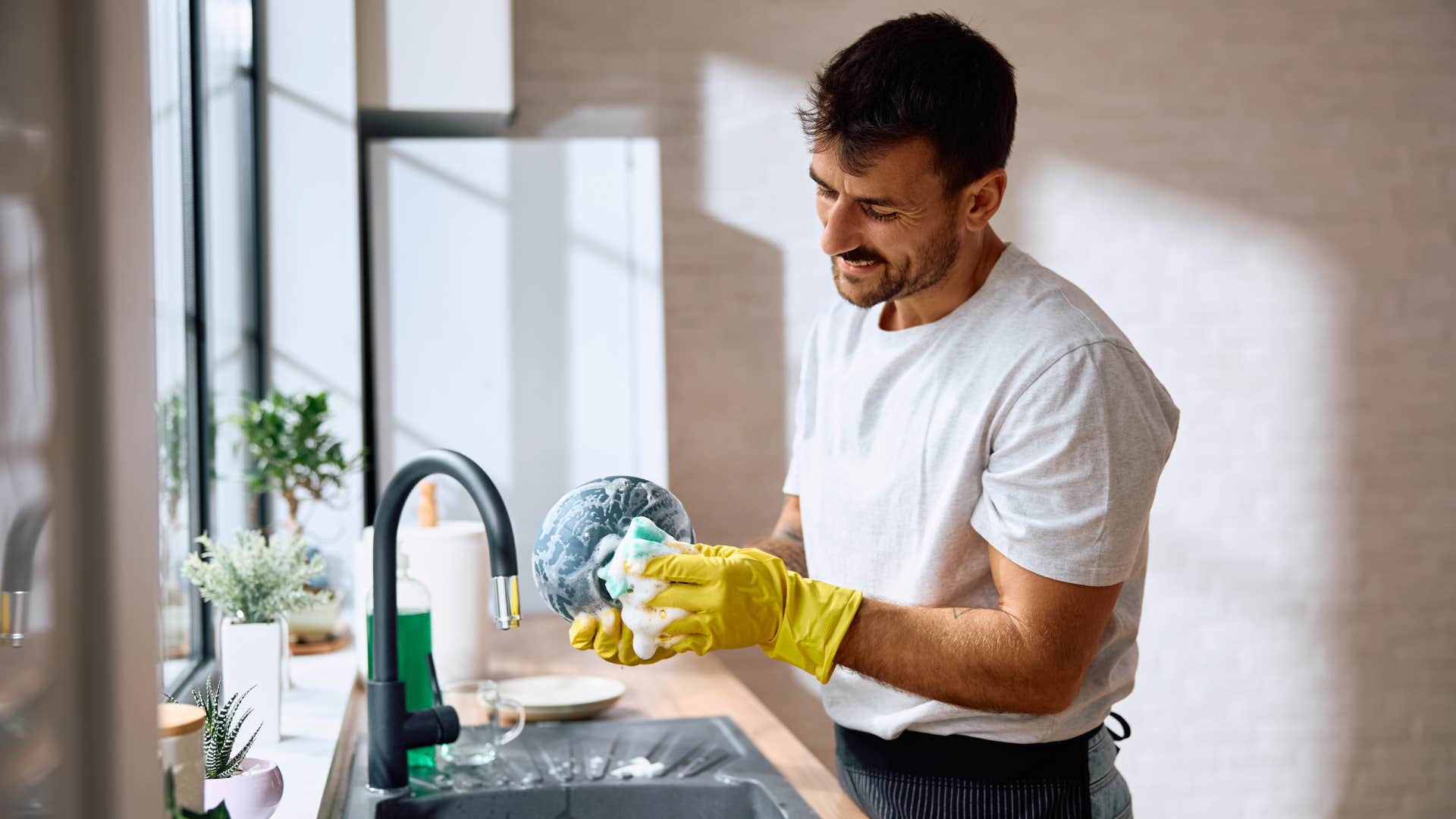 man cleaning the dishes at home alone