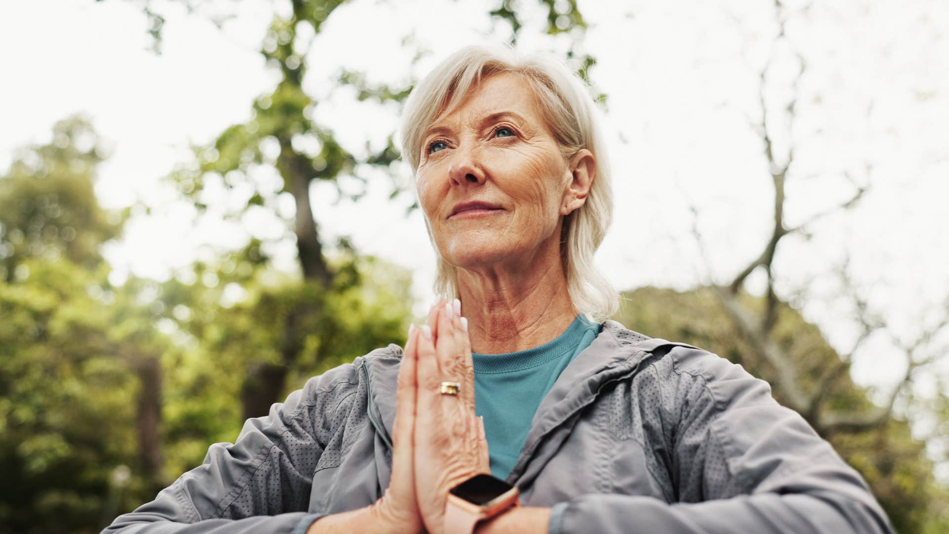 woman meditating in her backyard at home