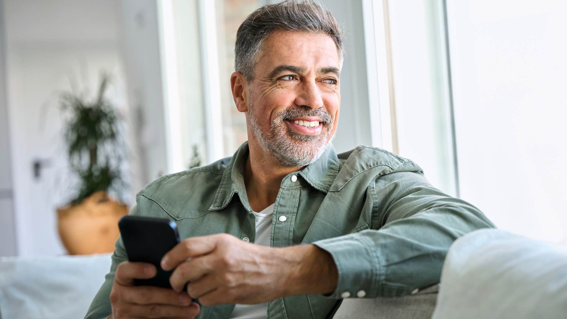 introverted man people-watching out his window at home
