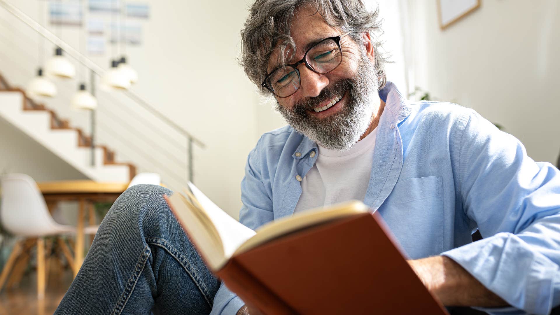 introverted man reading a book at home