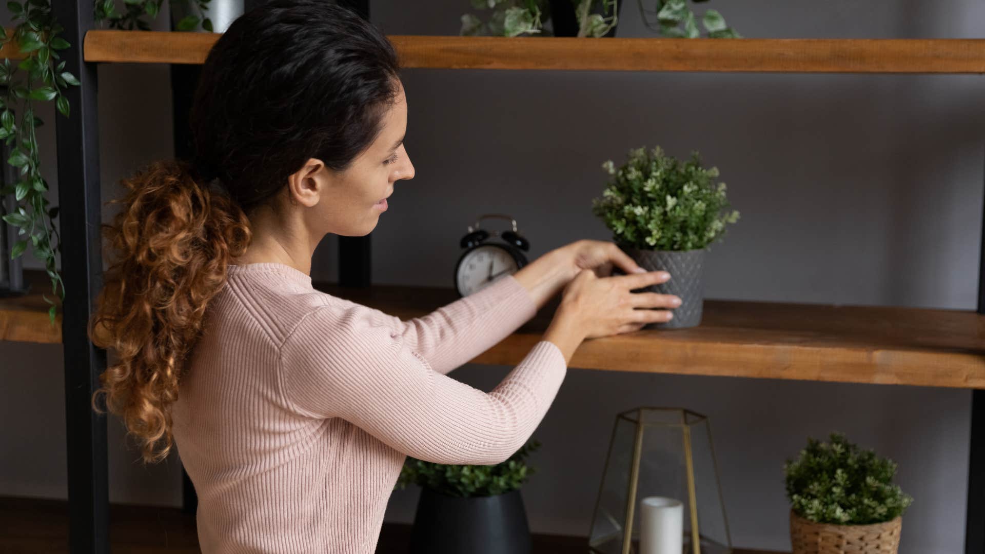 woman rearranging furniture and decor at home
