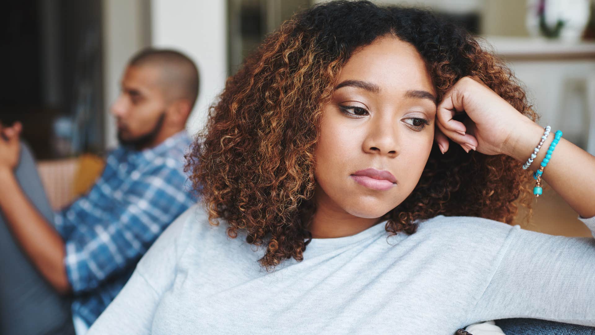 woman with a blank expression looking away from her husband
