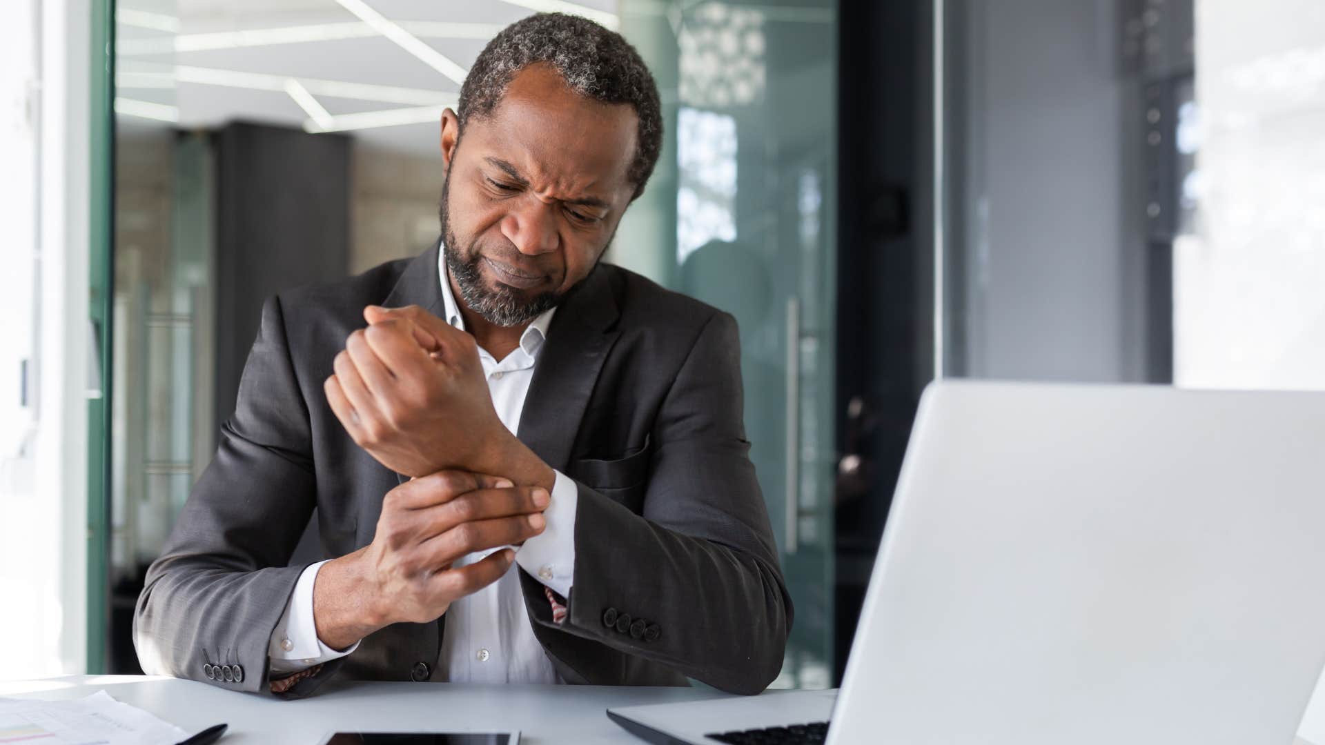 man with shaky hands looking annoyed at work