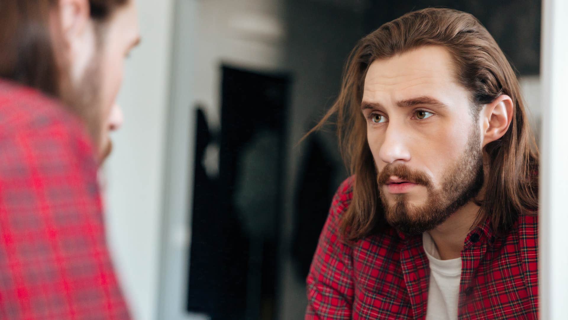 serious man looking in bathroom mirror
