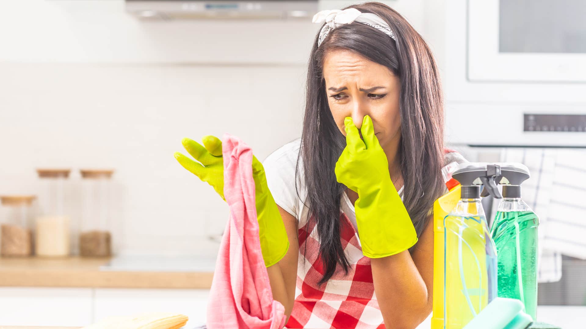 woman holding up dirty dish towels in her kitchen
