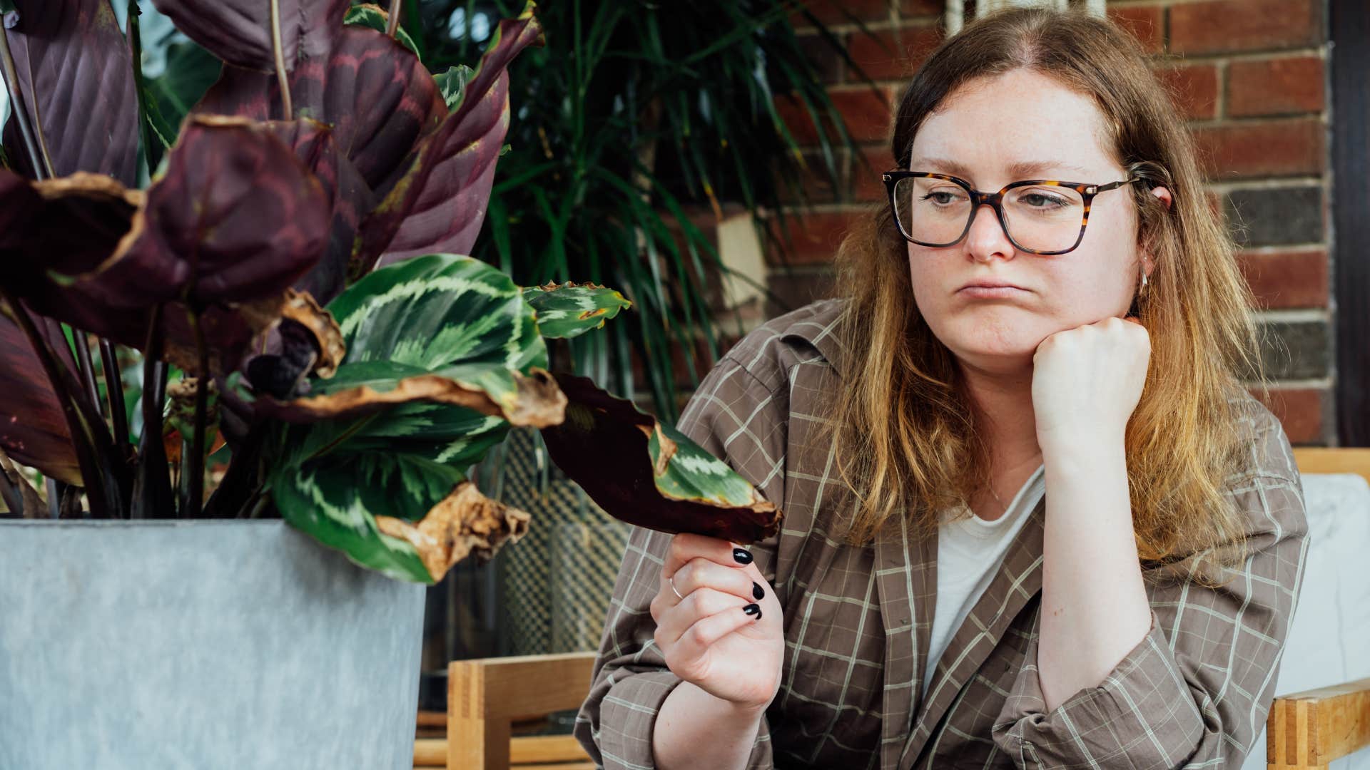 woman sitting with her neglected dying plants