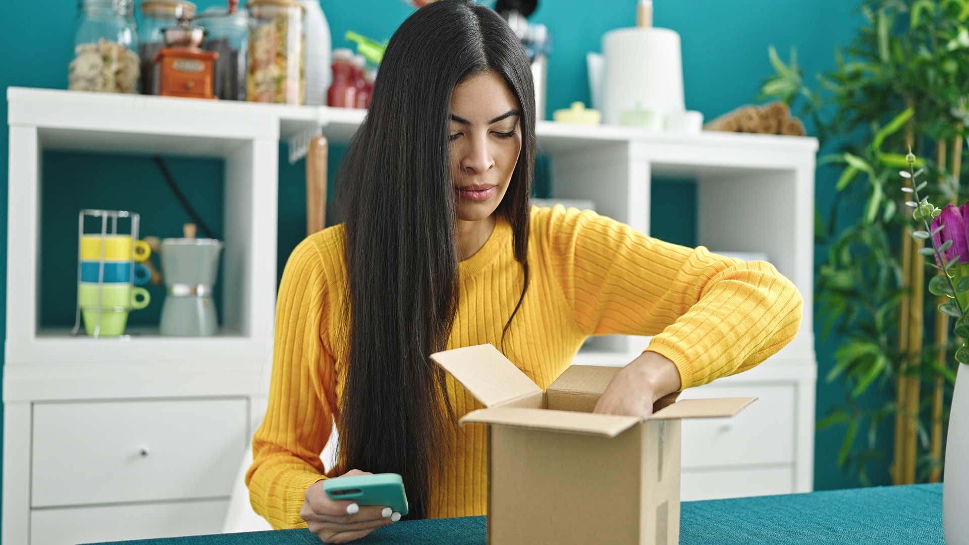 woman looking at piles of packages and mail in her kitchen