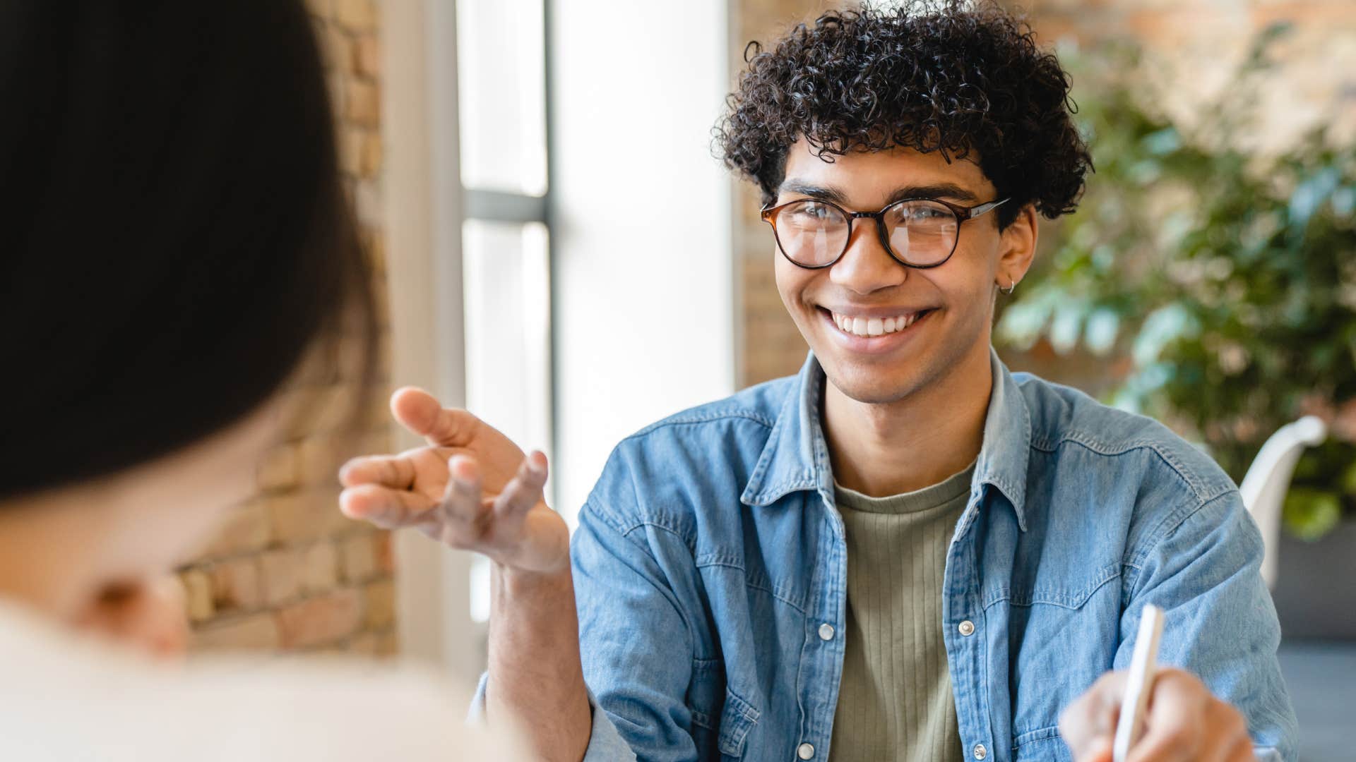 man noticing who's left out in a conversation and smiling