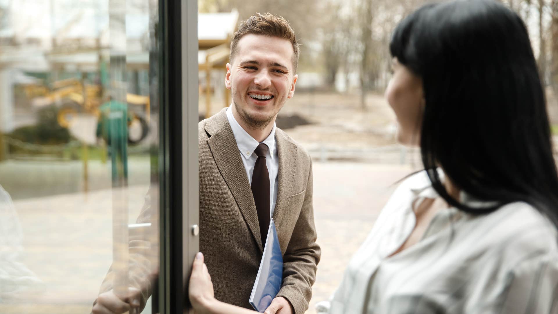 woman holding the door for others in public