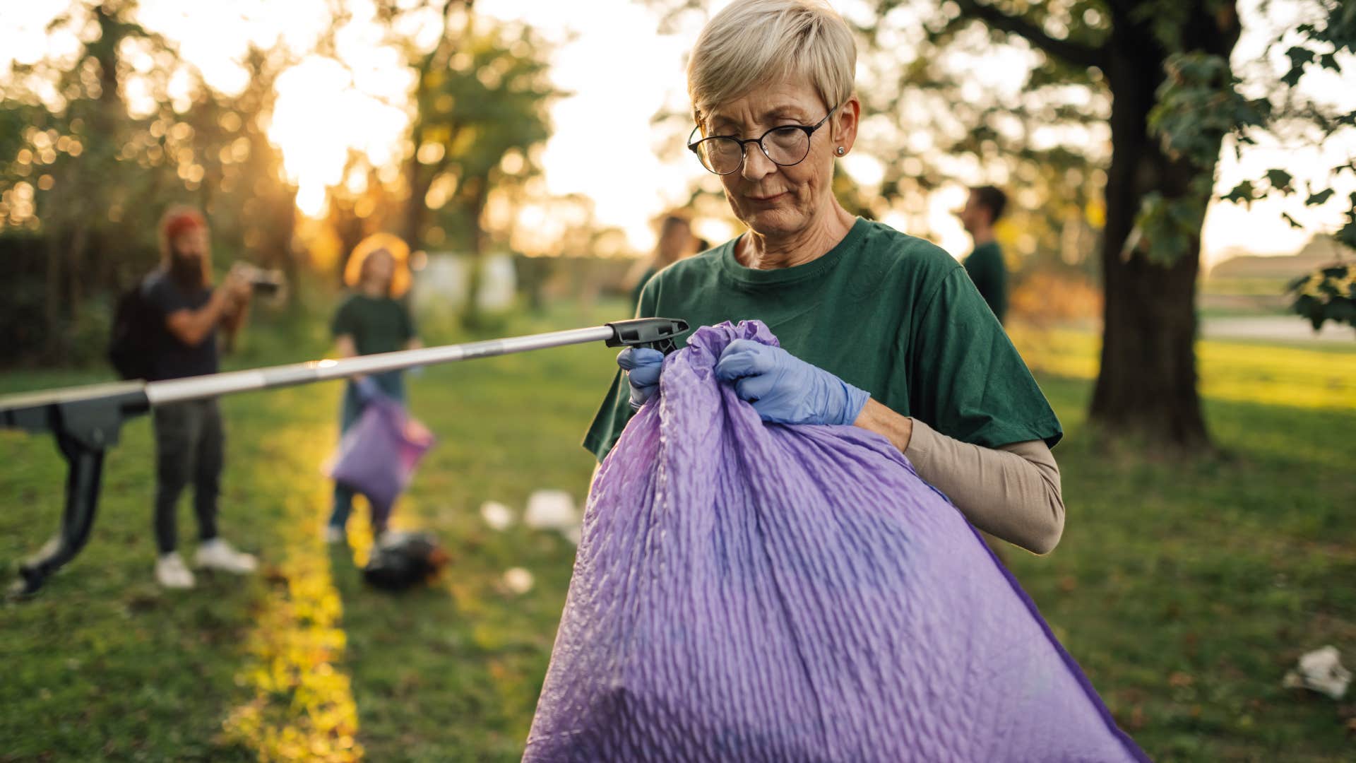 good woman picking up trash in a public park