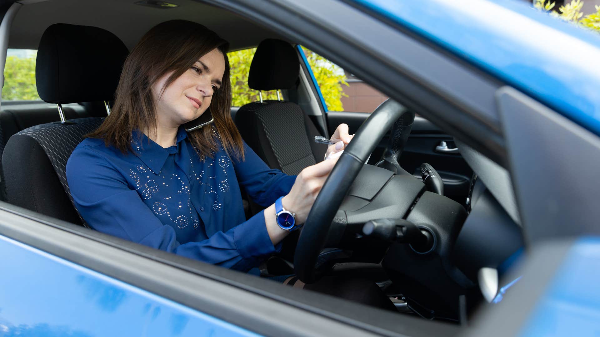 mom writing grocery list in car