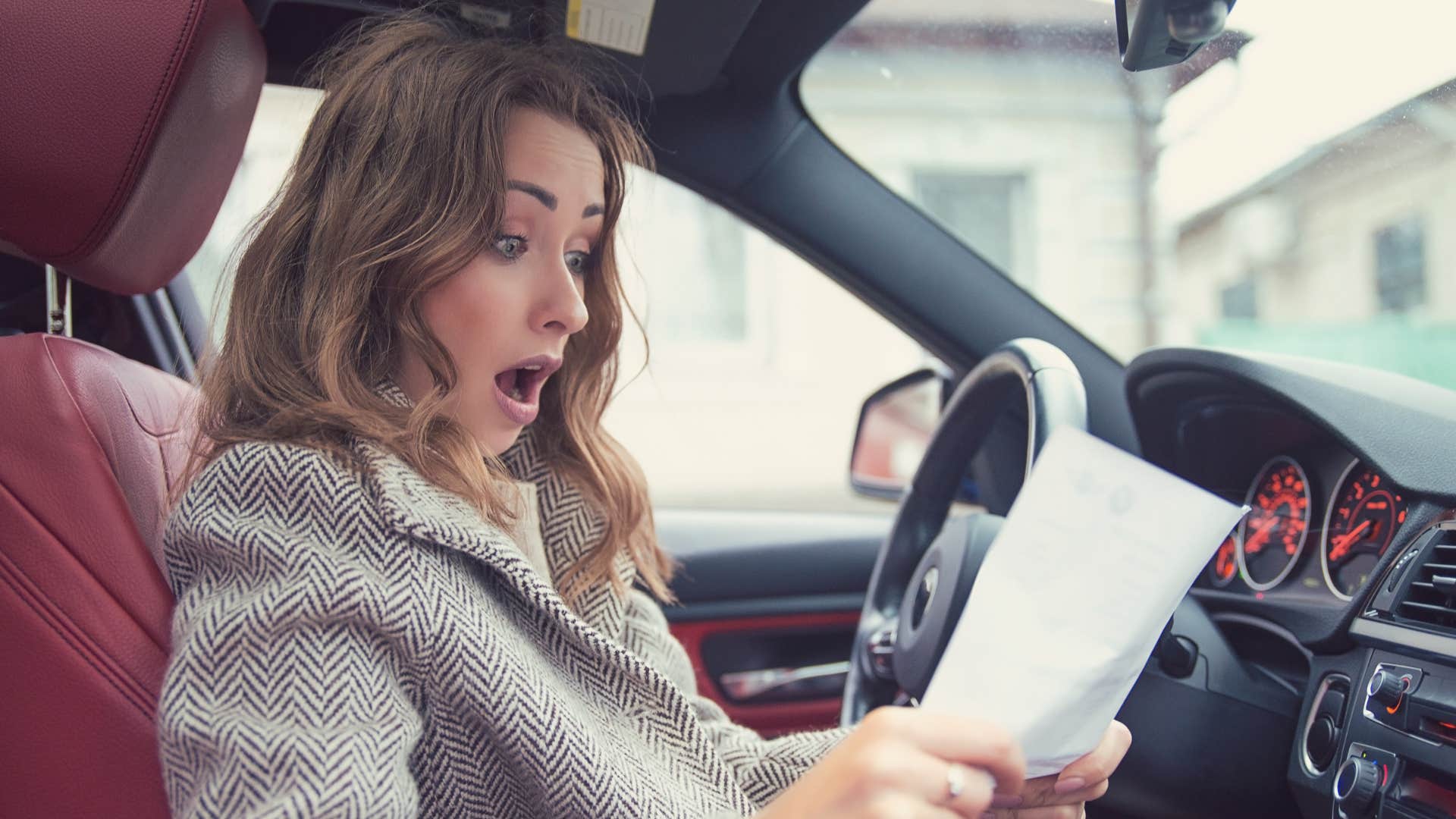 shocked mom reading school flyer in car
