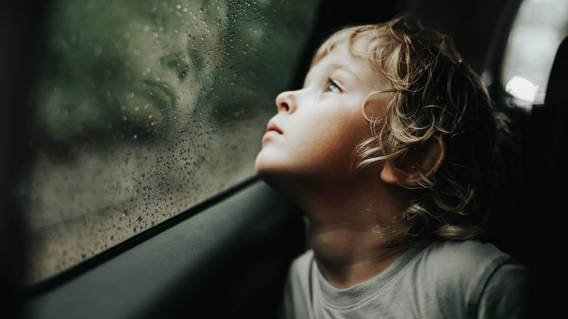 little boy looking out car window