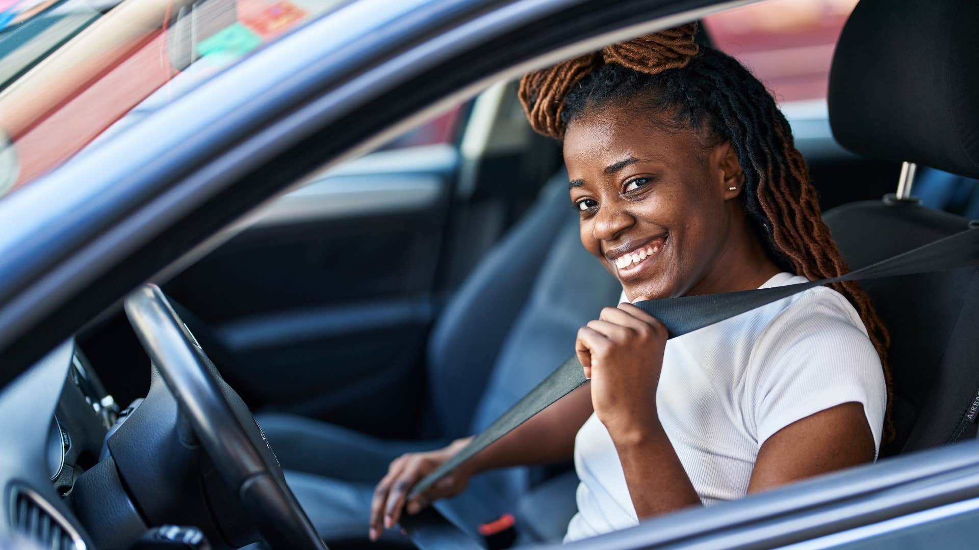 woman smiling in her car because it smells good