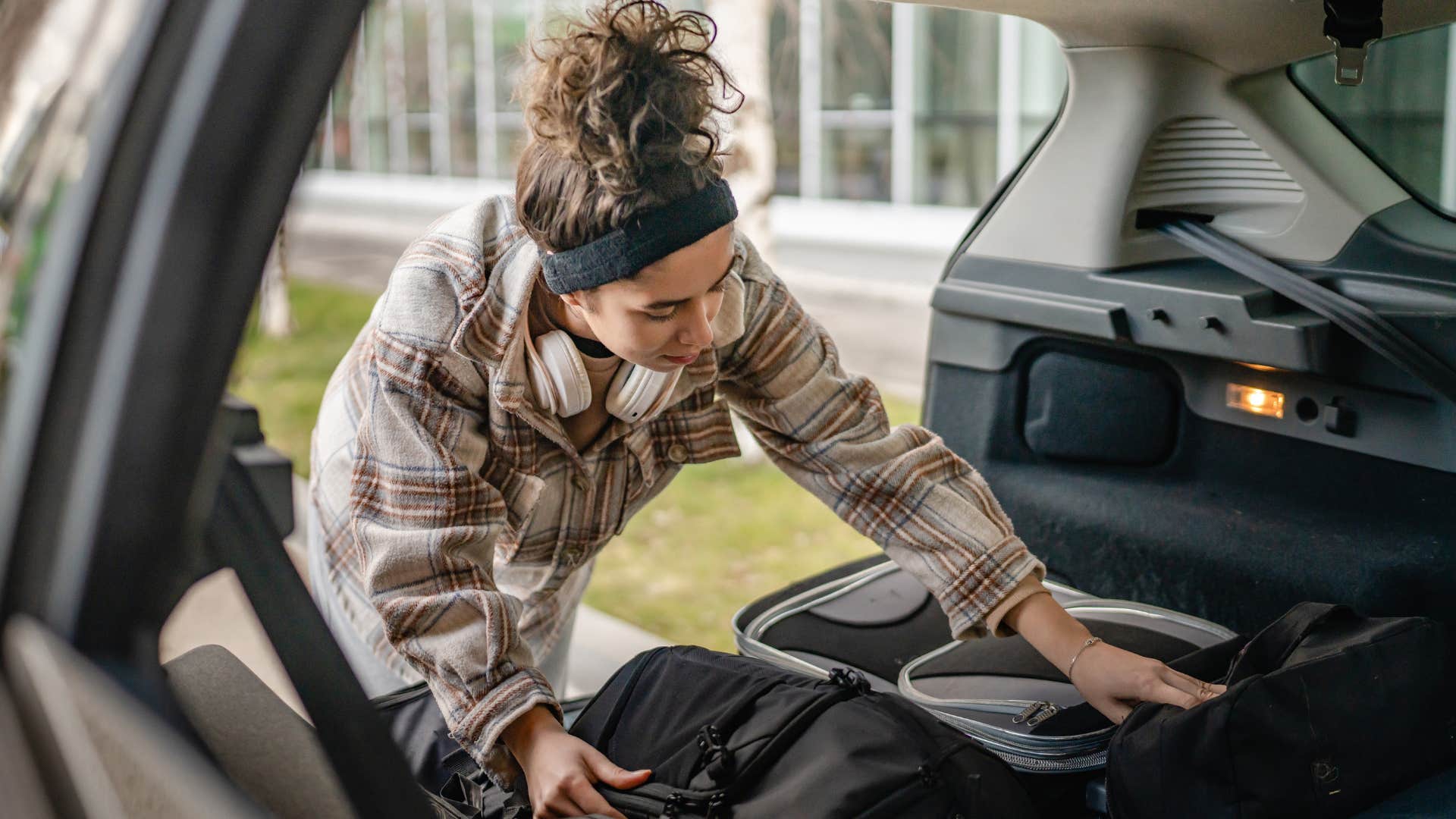 woman looking for extra clothes in her car trunk