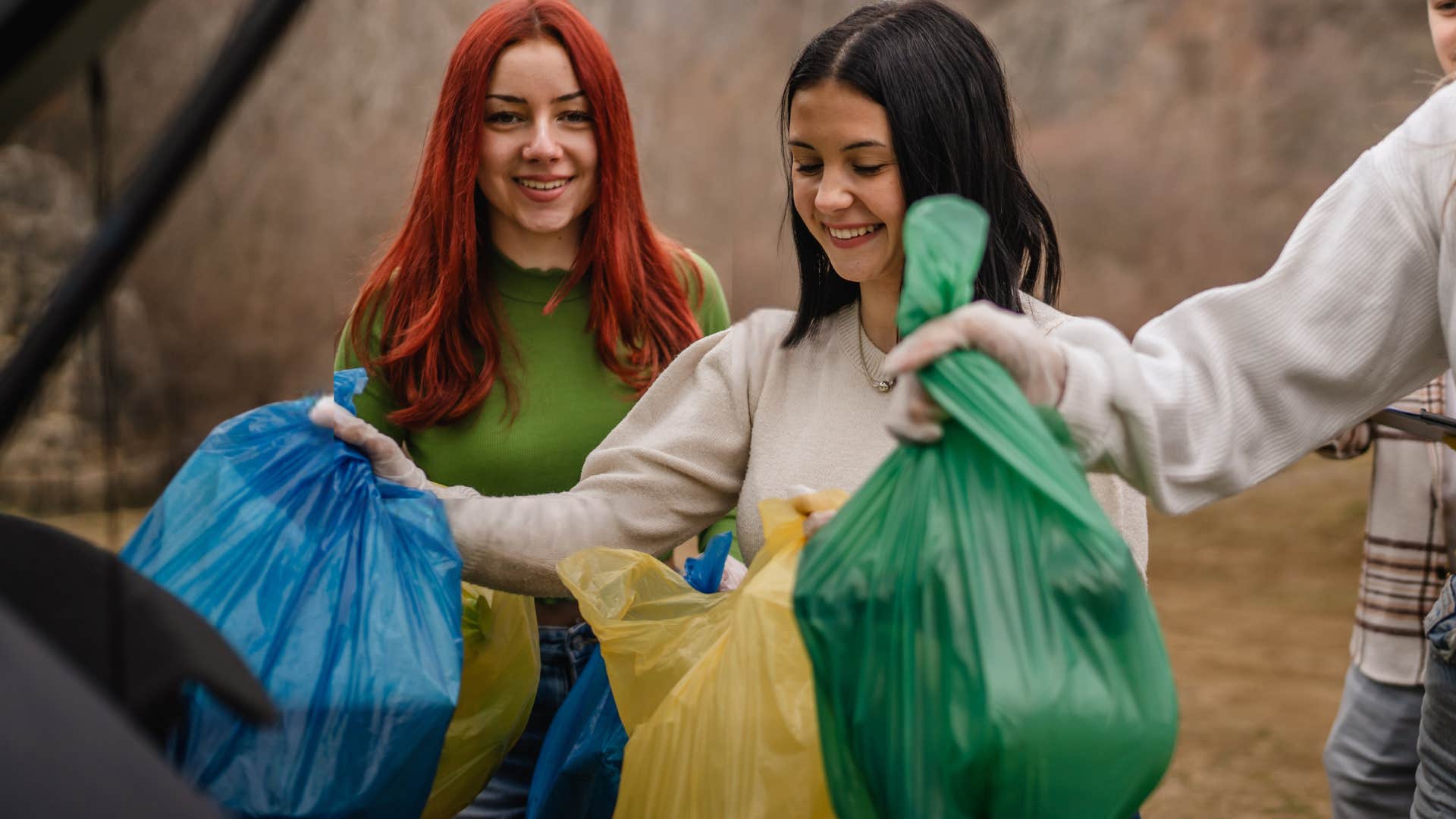 woman and friends removing trash bags from car