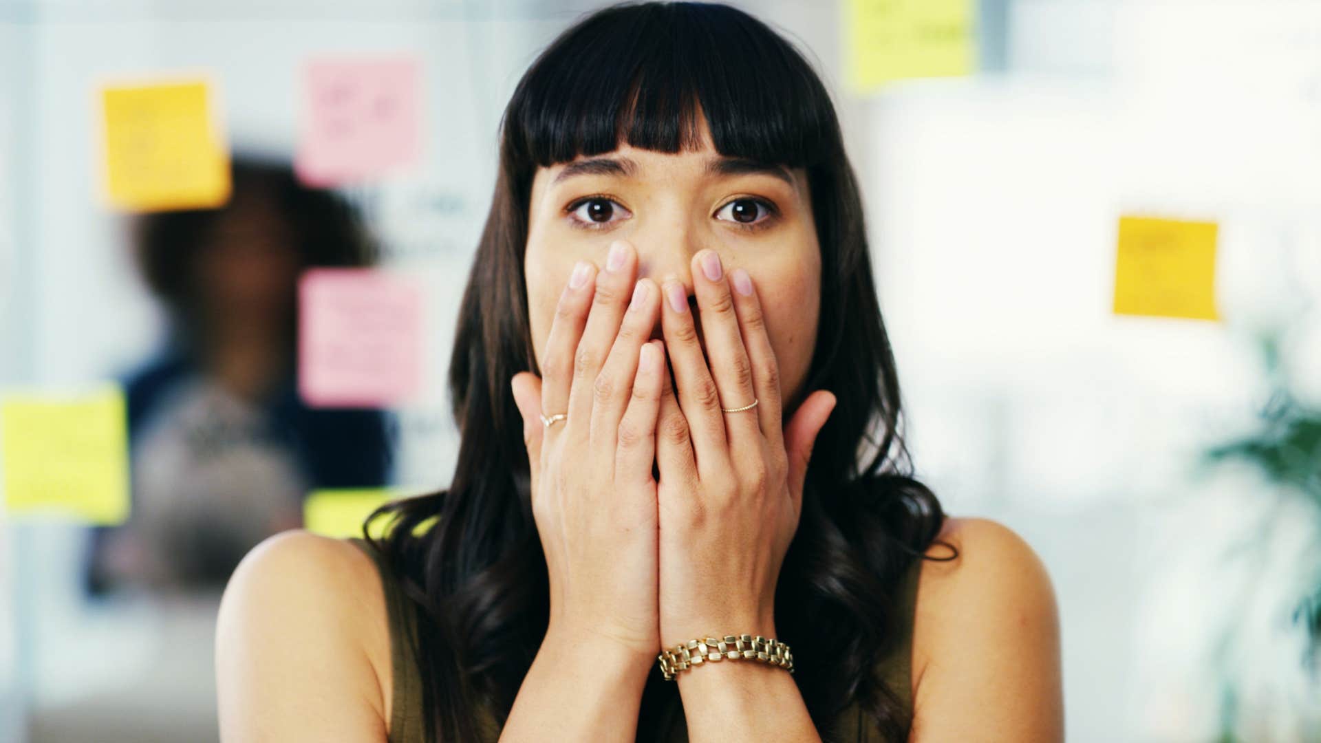 Woman looking at forgotten appointments on sticky notes.