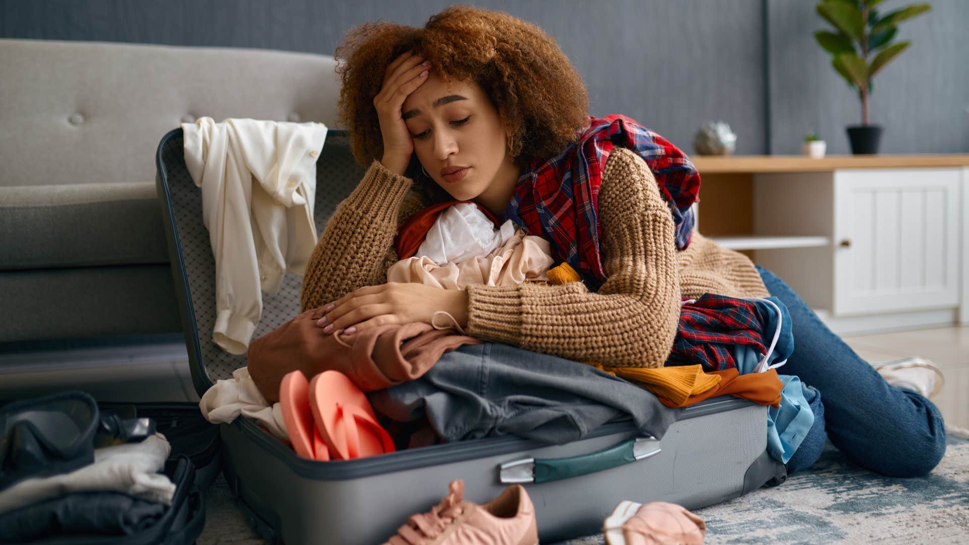 Woman laying on random unpacked bags at home.