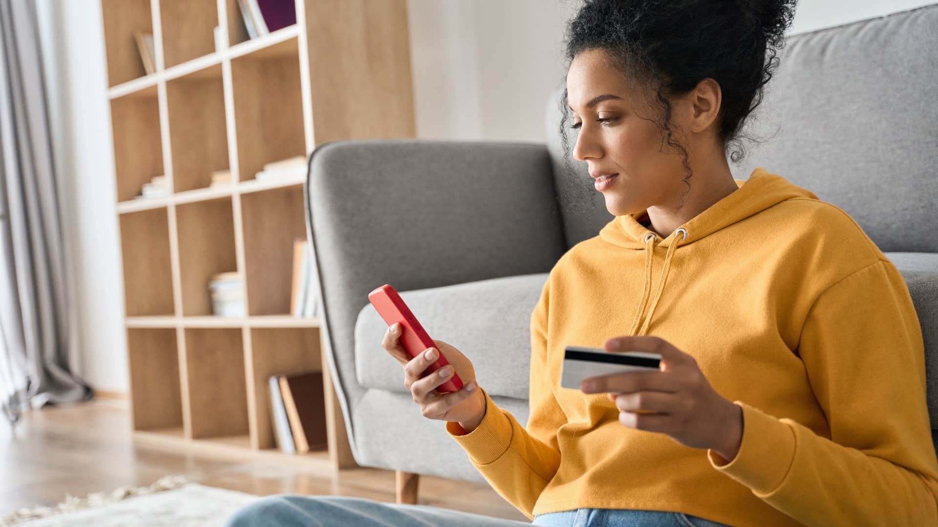 young woman looking up balance on credit card