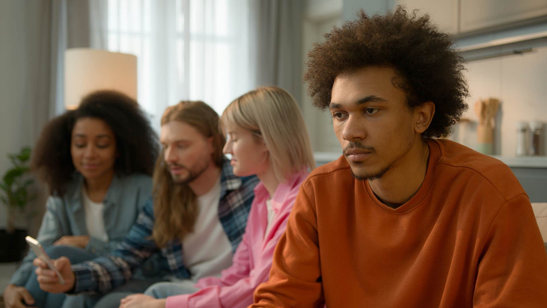 upset man sitting away from friends using past against him