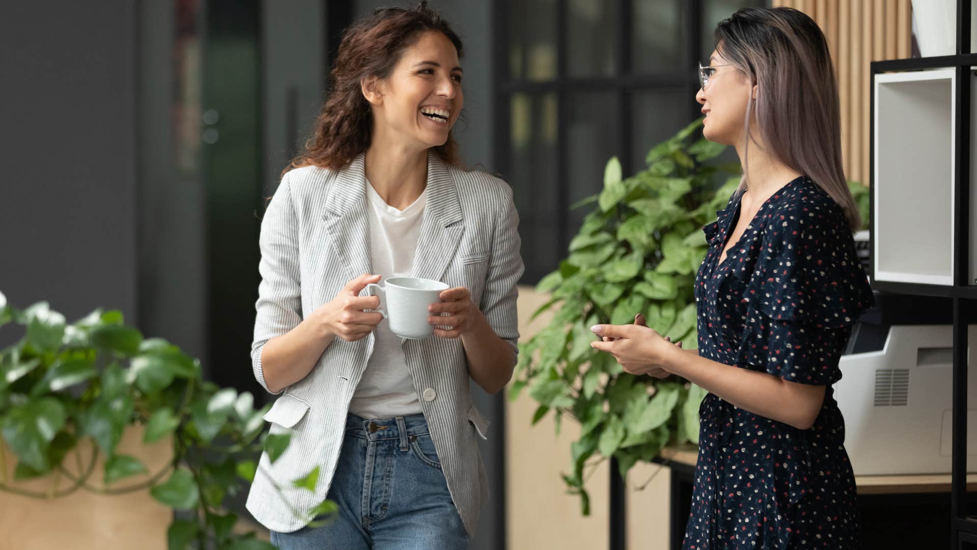 two co-workers fake smiling during conversation