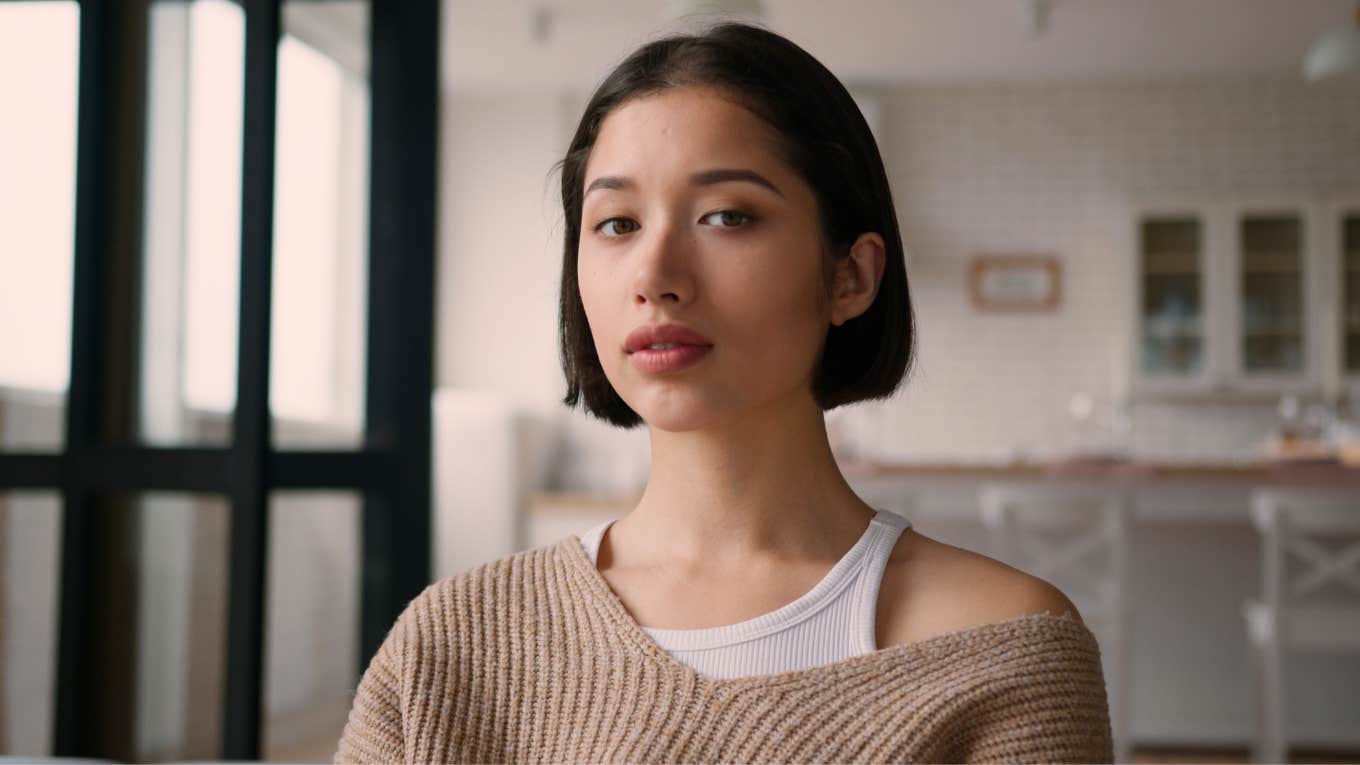 sad woman standing in her kitchen