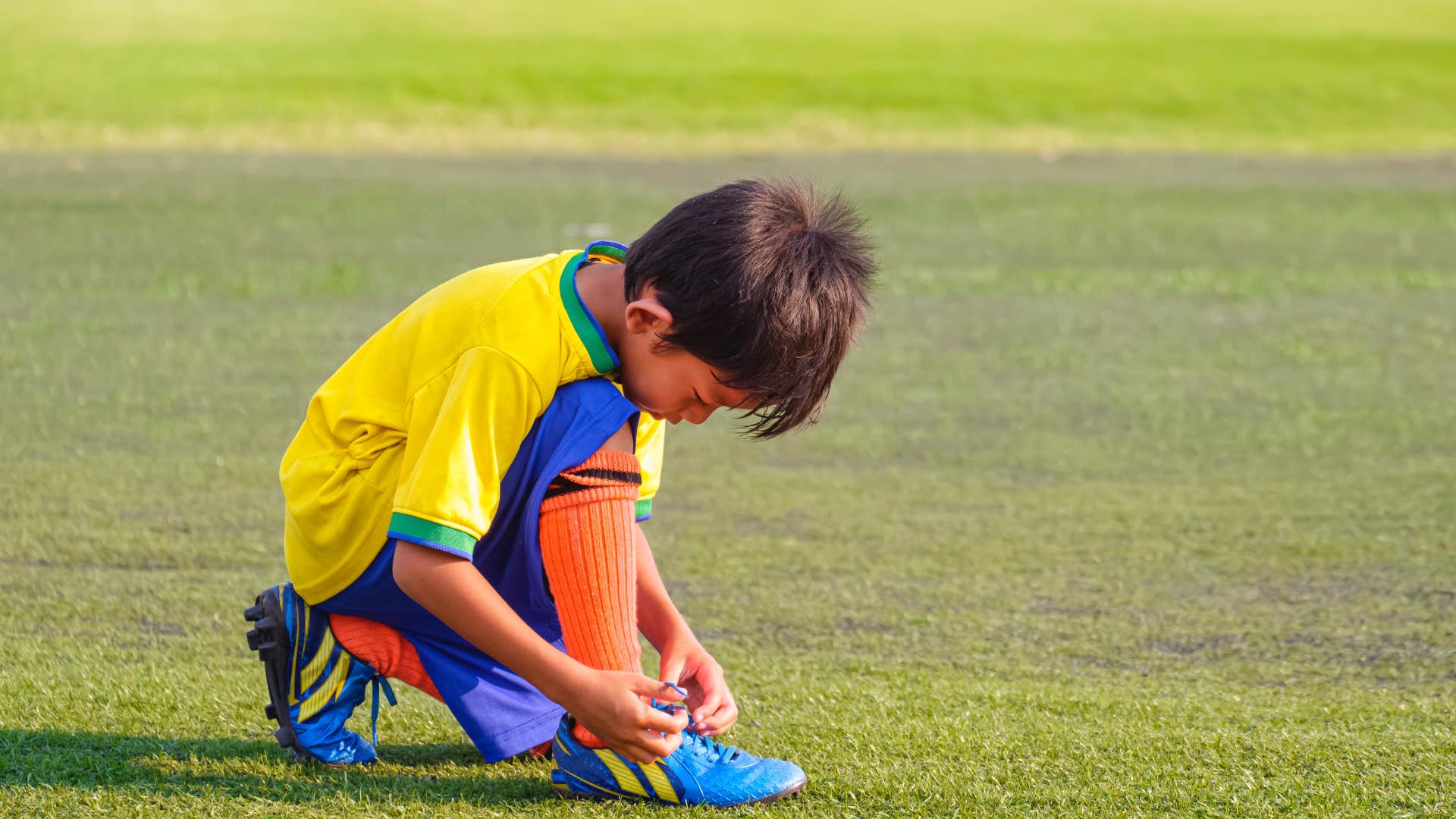 kid using the bunny ear method to tie his shoes